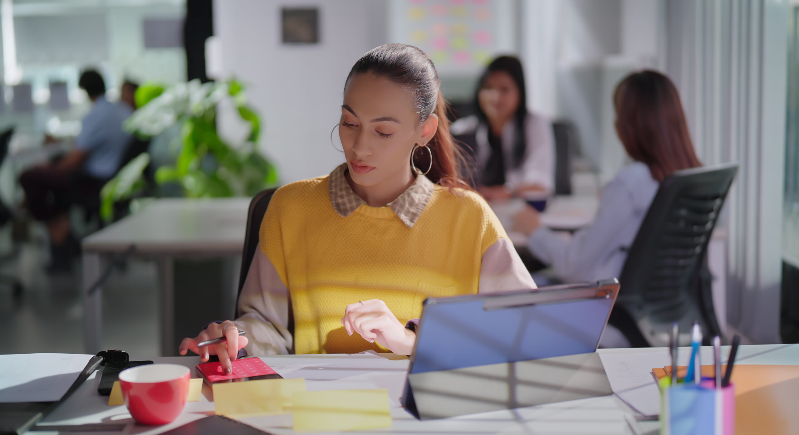 woman taking notes while taking on online training course on her tablet